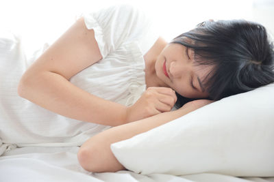 Young woman sleeping on bed at home