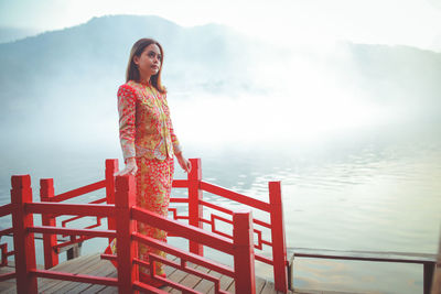 Asian woman wearing cheongsam traditional red dress on chinese new year travel.