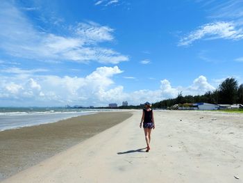 Woman on beach against sky