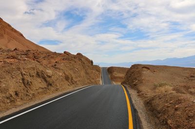 Road amidst mountains against sky