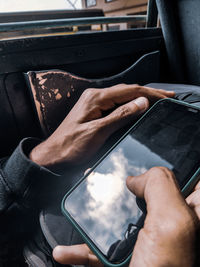 Midsection of man using mobile phone in bus