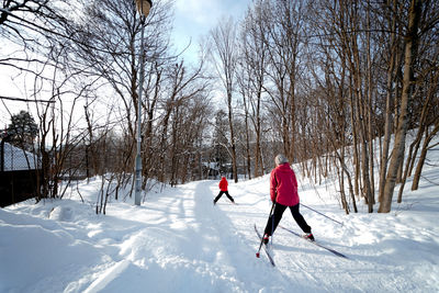 People on snow covered land against sky