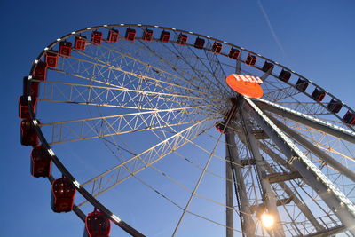 Low angle view of ferris wheel against blue sky