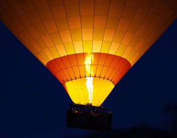 Low angle view of illuminated hot air balloon against clear sky at night