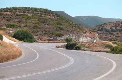 Road by mountains against sky