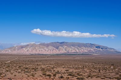 Scenic view of desert against blue sky