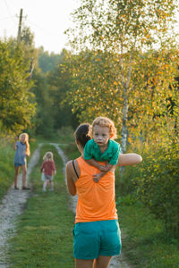 Full length of children on landscape against trees