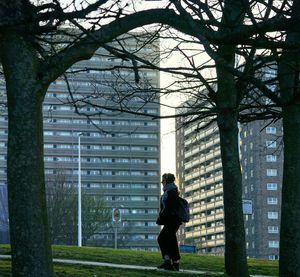 Rear view of woman standing by tree