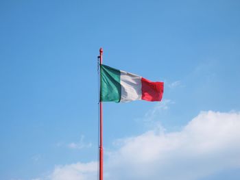 Low angle view of flag against blue sky