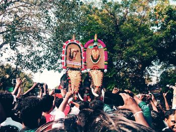 People standing against decorated elephants during pooram festival