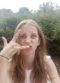 Portrait of young woman against trees