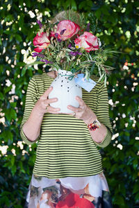 Midsection of woman holding flowers