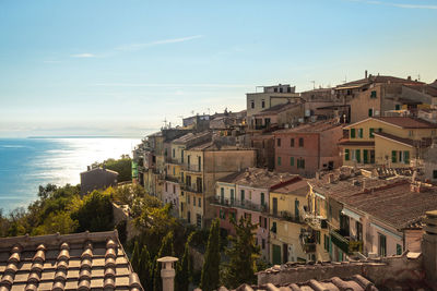 High angle view of townscape by sea against sky