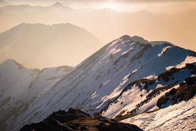 Scenic view of snowcapped mountains against sky during sunset