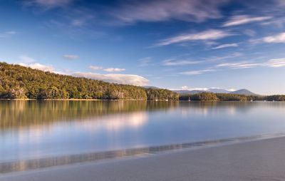 Scenic view of sky and forest reflected in bay at cockle creek