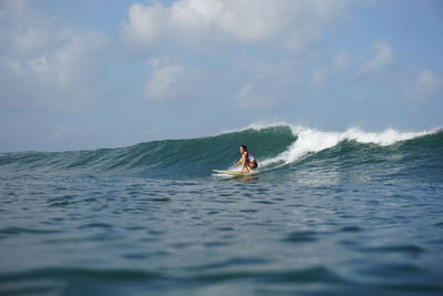 Man surfing in sea against sky