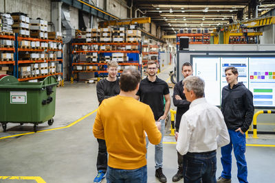 Businessman and manager planning with employees in meeting at factory