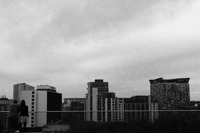 Buildings in city against cloudy sky