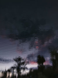 Scenic view of trees against sky at dusk