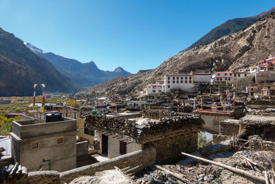 Buildings in town against clear blue sky