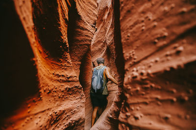 Young man exploring narrow slot canyons in escalante, during summer