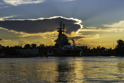 Silhouette of church at riverbank during sunset