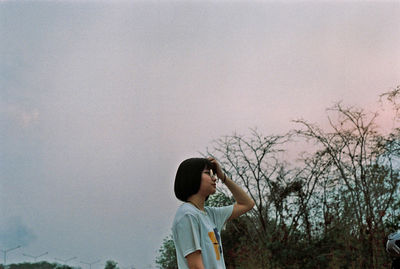 Boy looking at camera against sky