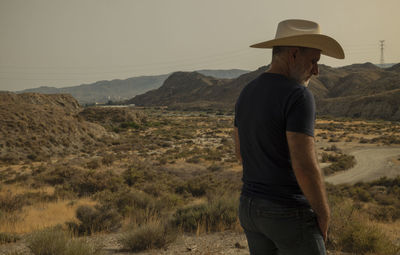 Rear view of adult man in cowboy hat in desert. almeria, spain