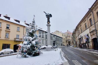 Street amidst buildings against sky during winter