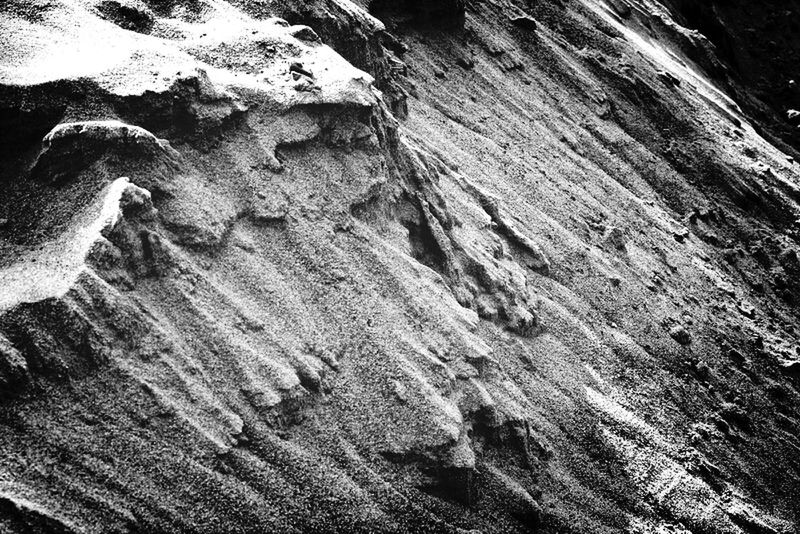 textured, natural pattern, nature, rough, sand, rock formation, tranquility, high angle view, rock - object, beauty in nature, close-up, geology, one person, day, outdoors, physical geography, beach, sunlight, tranquil scene, pattern