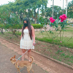 Full length of woman with dog against plants