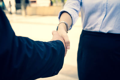 Midsection of couple holding hands