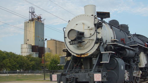 Steam train against factory