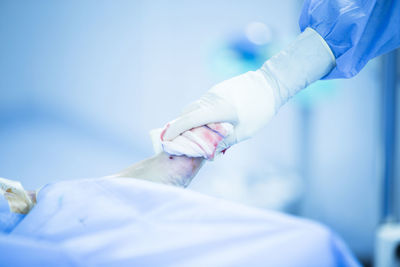 Close-up of surgeon cleaning patient wounded foot in operating room