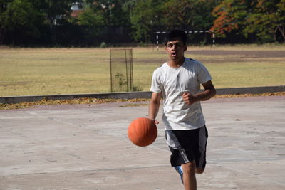 Young man playing basketball on court