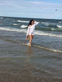 Full length of man standing on beach against sea