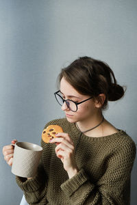 Woman holding coffee cup against white background