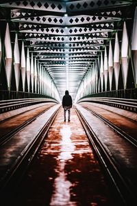 Rear view of mature man standing on bridge