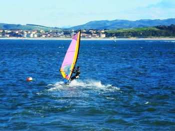 Man surfing in sea against sky