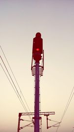 Low angle view of silhouette telephone pole against sky during sunset