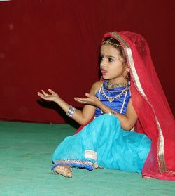 Cute girl wearing traditional dress dancing on stage