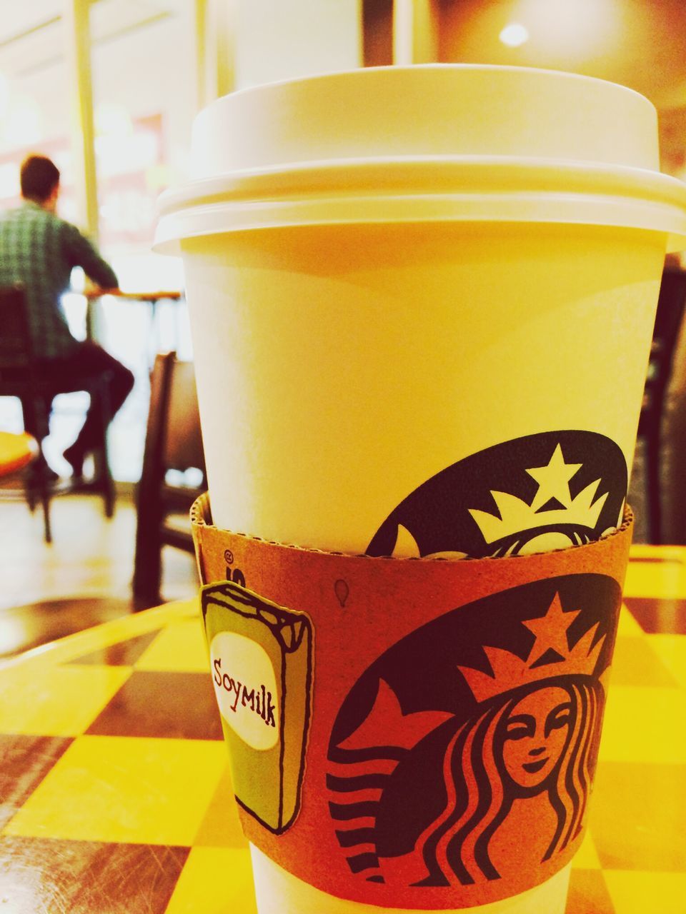 indoors, focus on foreground, close-up, food and drink, yellow, table, still life, drink, text, refreshment, incidental people, communication, western script, coffee cup, art, no people, day, cafe, art and craft, freshness