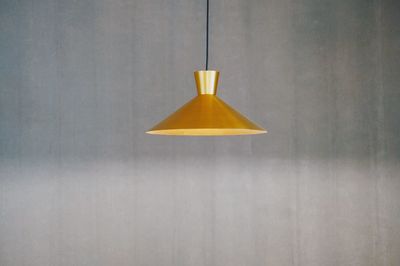 Close-up of electric lamp against wall at home