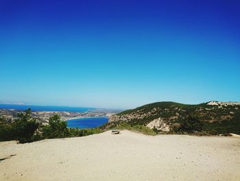 View of calm beach against blue sky