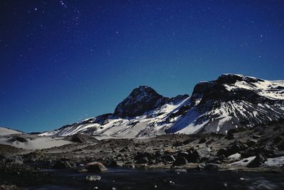 Scenic view of snowcapped mountains against sky at night