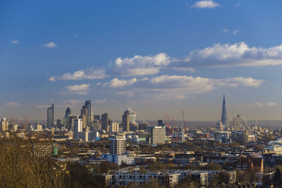 View of cityscape against cloudy sky