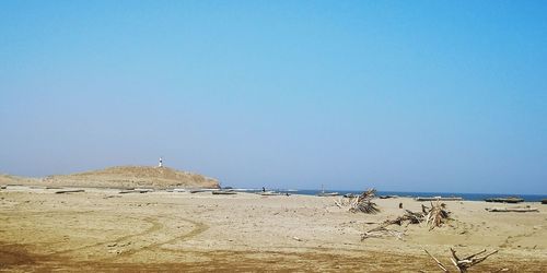 Scenic view of beach against clear blue sky