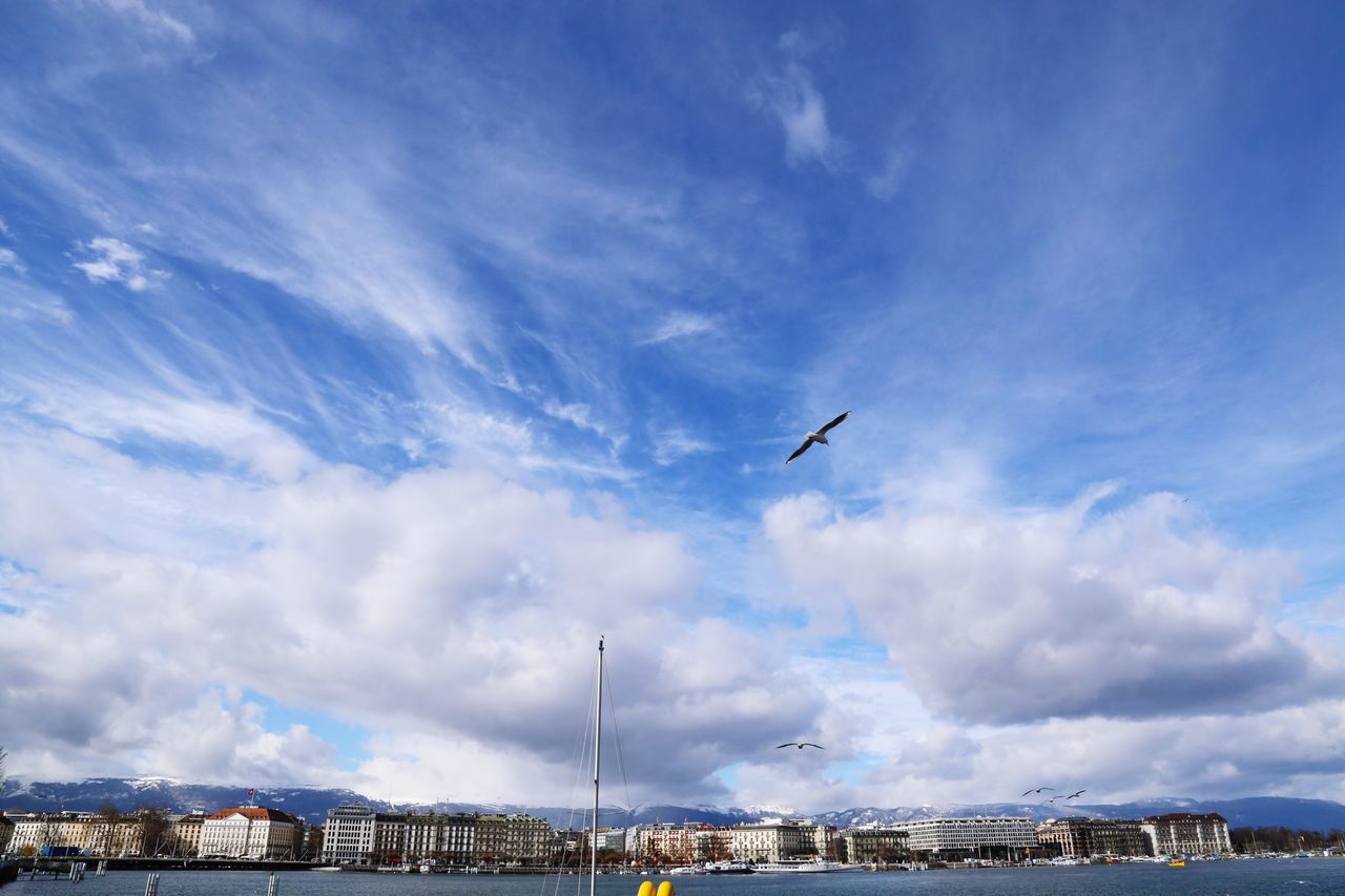 sky, cloud - sky, built structure, architecture, building exterior, city, transportation, flying, cityscape, blue, cloudy, mode of transport, travel, cloud, airplane, day, outdoors, travel destinations, air vehicle, no people