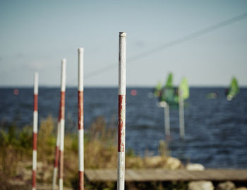 Close-up of wooden posts against sea and clear sky