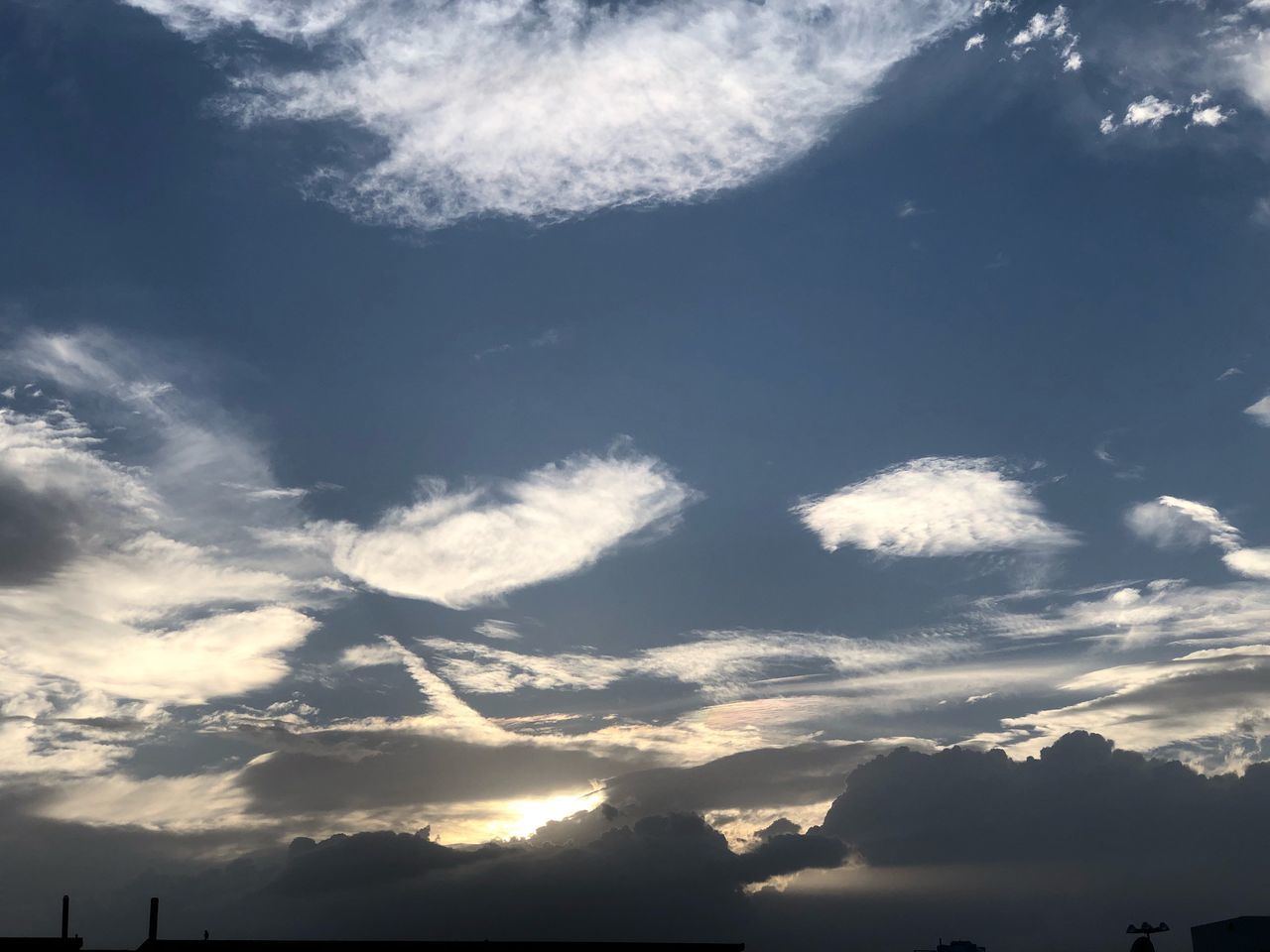 LOW ANGLE VIEW OF SUN SHINING THROUGH CLOUDS